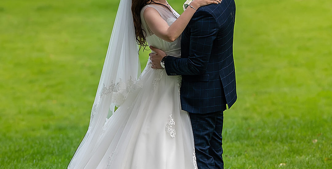 Dr. AJ and Zina holding each other at Cornwall Park, with an amazing wedding reception at Novotel Auckland.