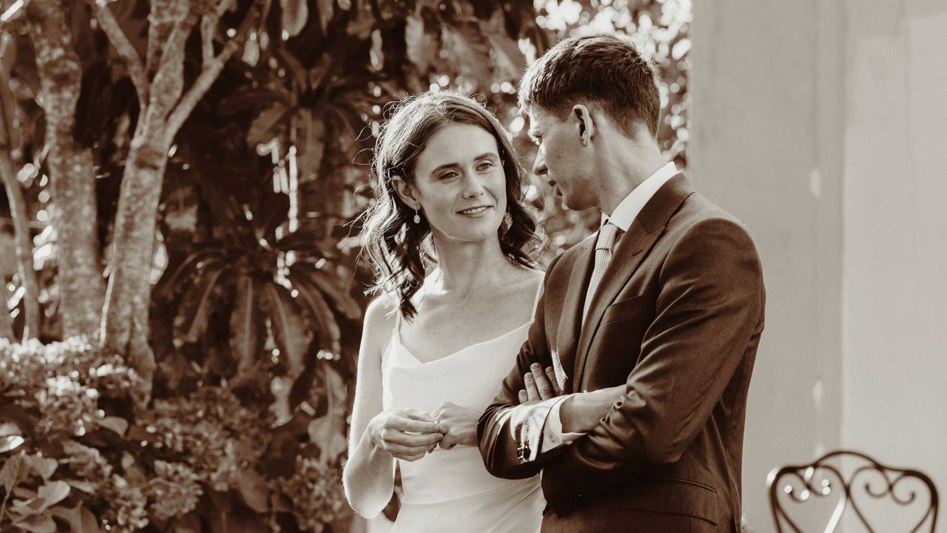 Auckland backyard wedding captured by HAPfilm showing the couple sharing a tender moment in a garden setting.