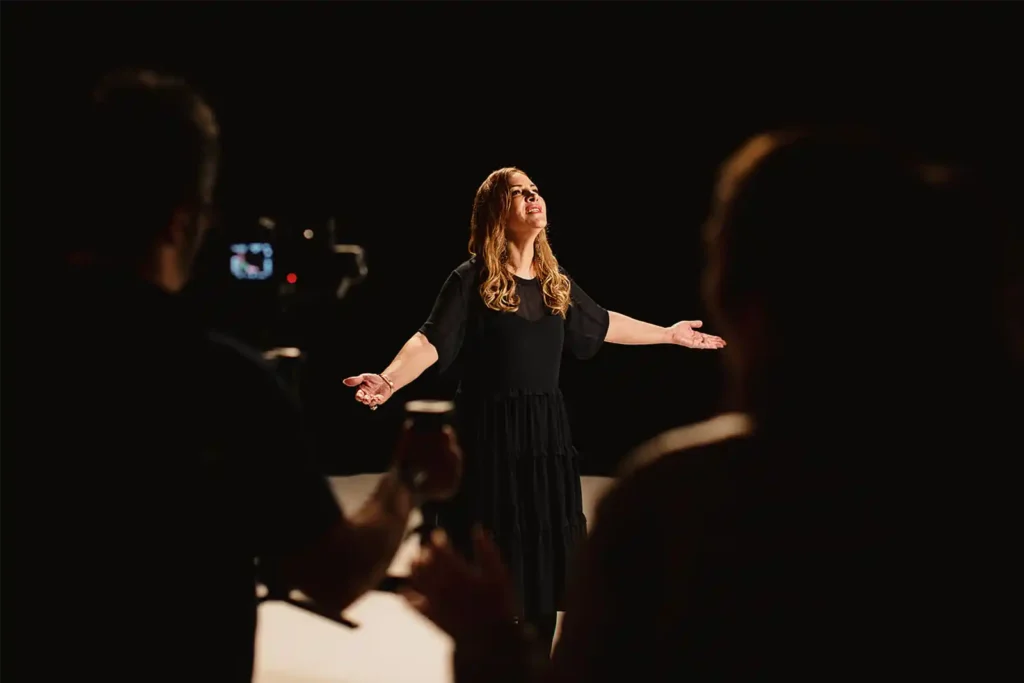 A behind-the-scenes look at the filming of the music video Sarnevesht, showing the HAPfilm crew setting up lighting, cameras, and stage decor with artist Sonbol Taefi on set in Auckland, New Zealand.