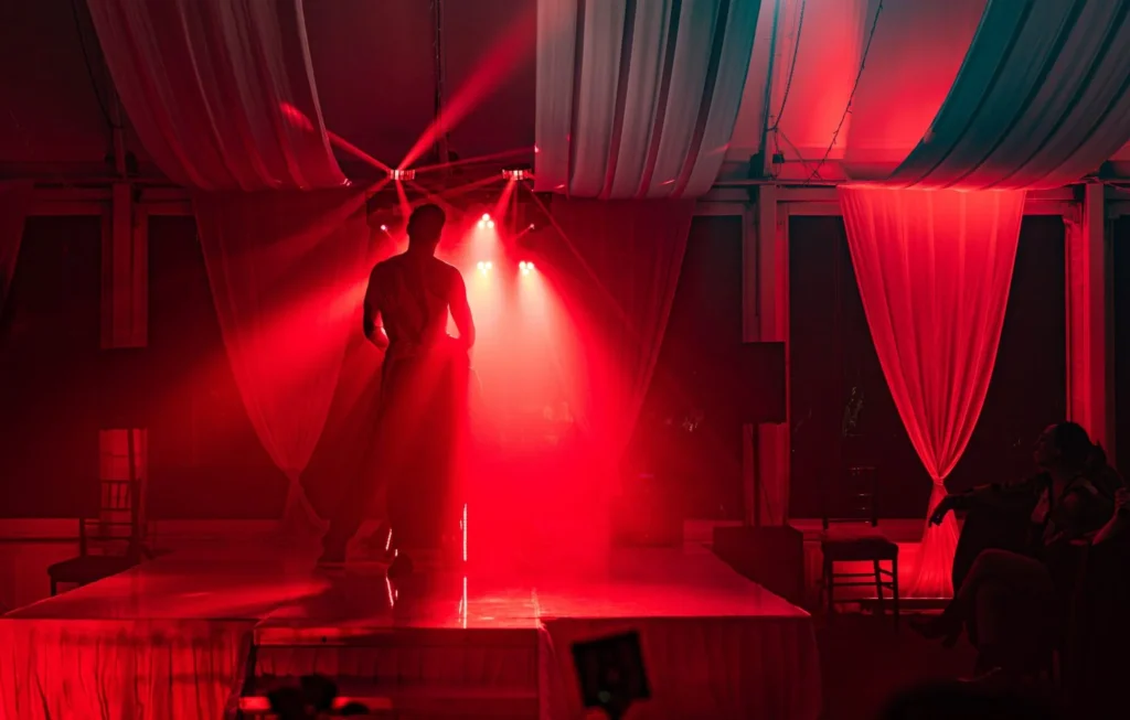 The Men of Steel performers on stage at Allely Estate, enhanced by dramatic red lighting during their energetic performance.