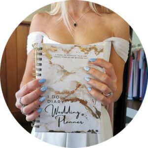 LOGO -A bride holding the I Do Diary wedding planner book, showcasing her beautifully manicured nails and elegant off-the-shoulder dress.