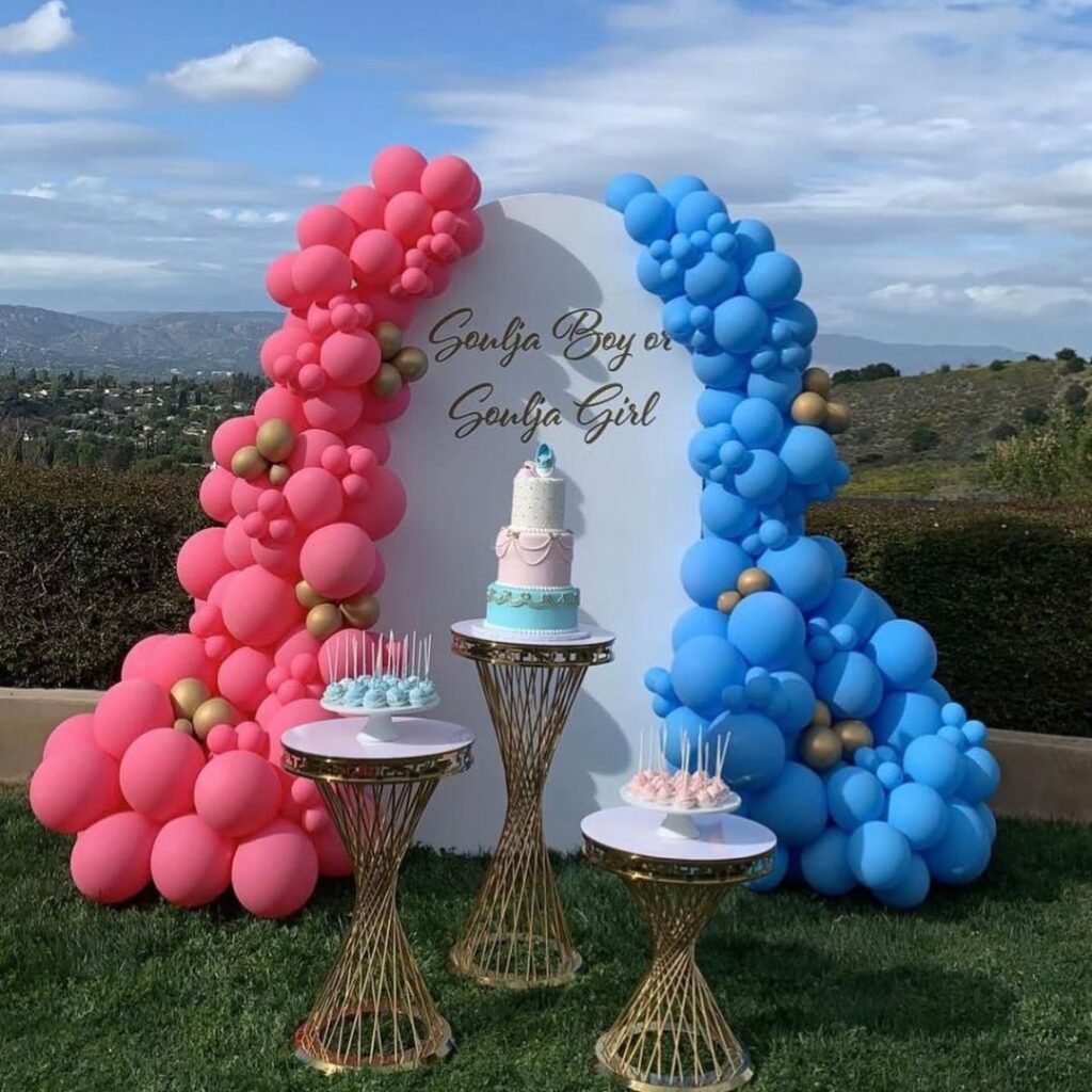 Organic balloon decor in neutral blush, beige, and rose gold metallic tones over three white arched backdrop plinths, styled for a modern Auckland event.
